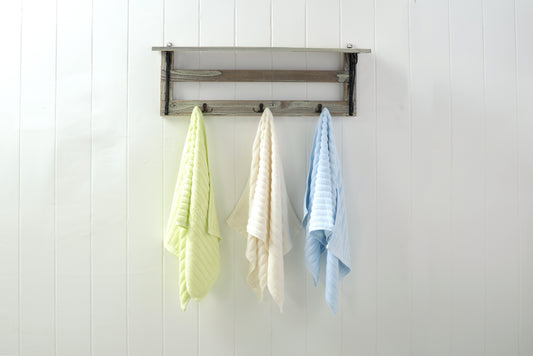 Green, white and blue bamboo hand towels hanging on hooks